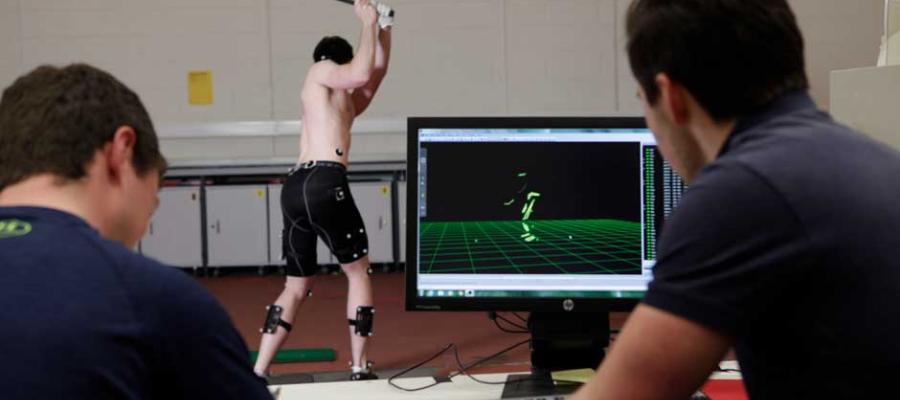 Researchers looking at a golfer on a computer screen