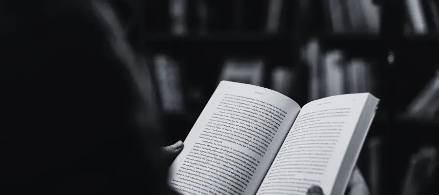 A person reading a book in a library