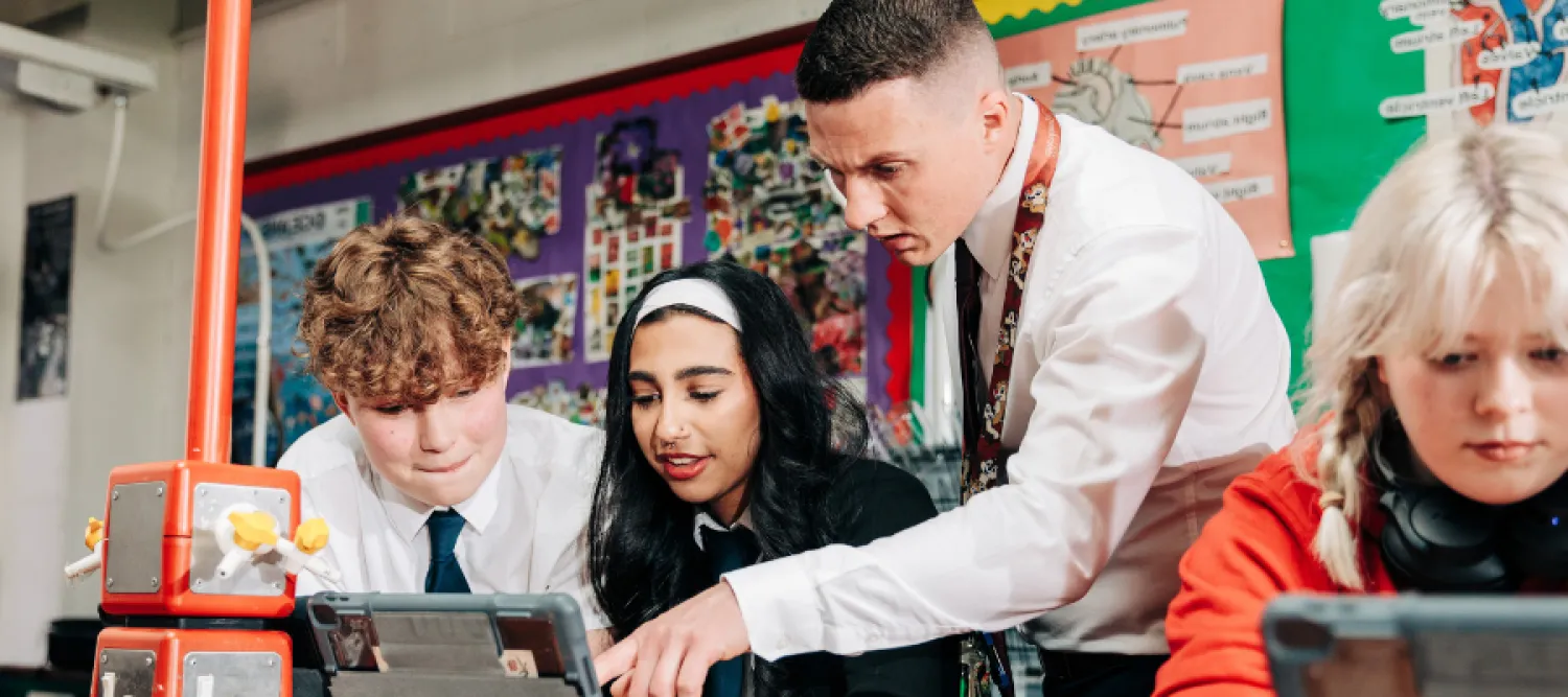Male teacher helping students