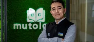 Sirojiddin Olimov stands infront of Mutolaa brand