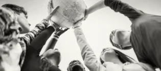 Group of people holding up a globe