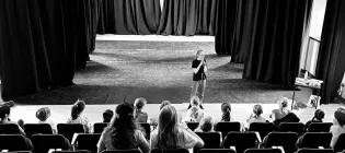Rachel standing on a stage speaking to an audience