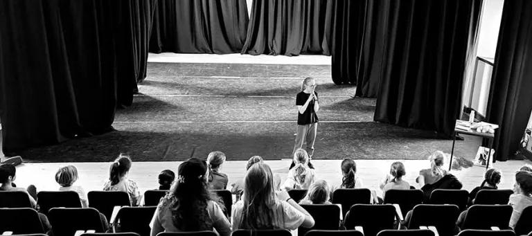 Rachel standing on a stage speaking to an audience