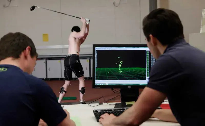 Researchers looking at a golfer on a computer screen