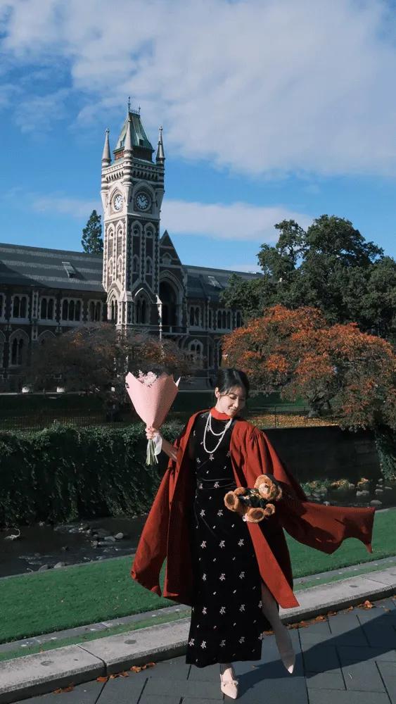 Yanling holding flowers in front of a fancy building