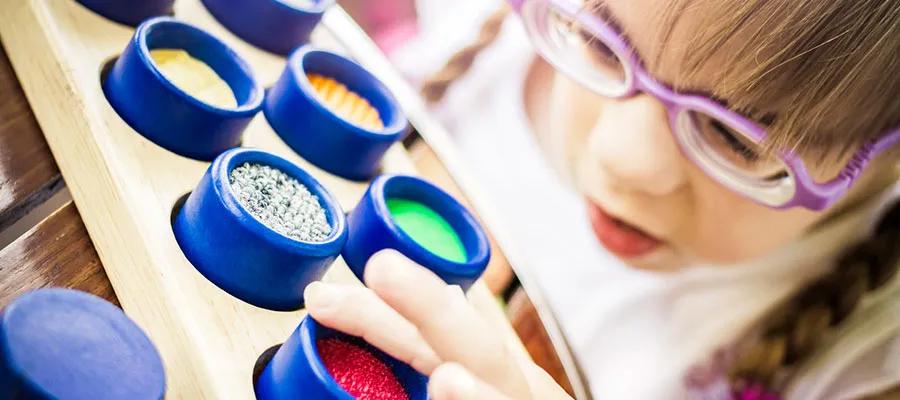 Visually impaired girl playing with colourful textured rolls