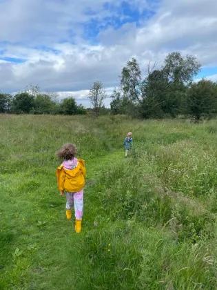 Two children running through a field