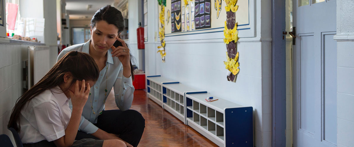 Teacher providing support to upset pupil